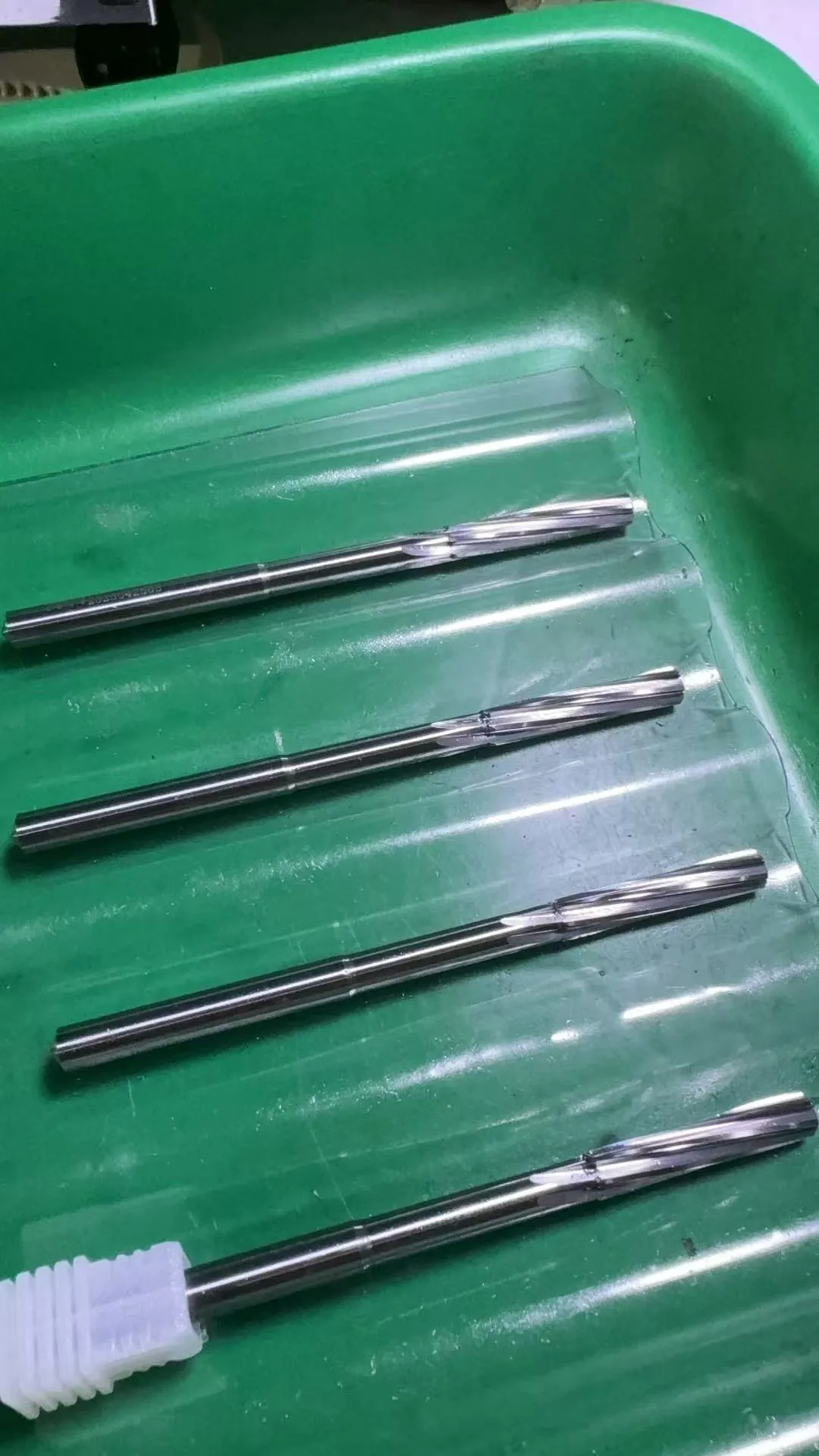 Solid carbide reamers with neck relief for clearance, photographed in the workshop before coating